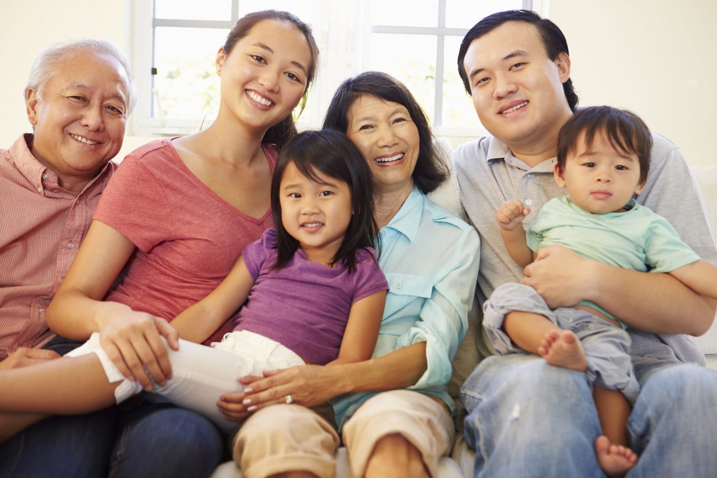Multi generation family sitting on a sofa at home together