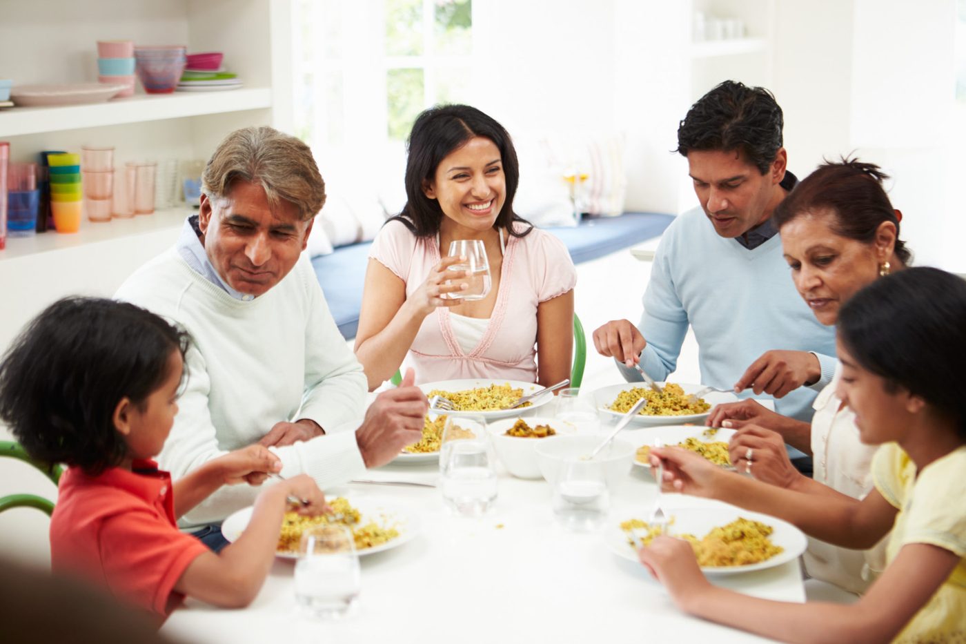Multi generation Indian family eating a meal at home